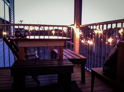 Cozy outdoor patio setup with twinkling string lights, captured by Justin Adelmann, creating a warm and inviting atmosphere during dusk.